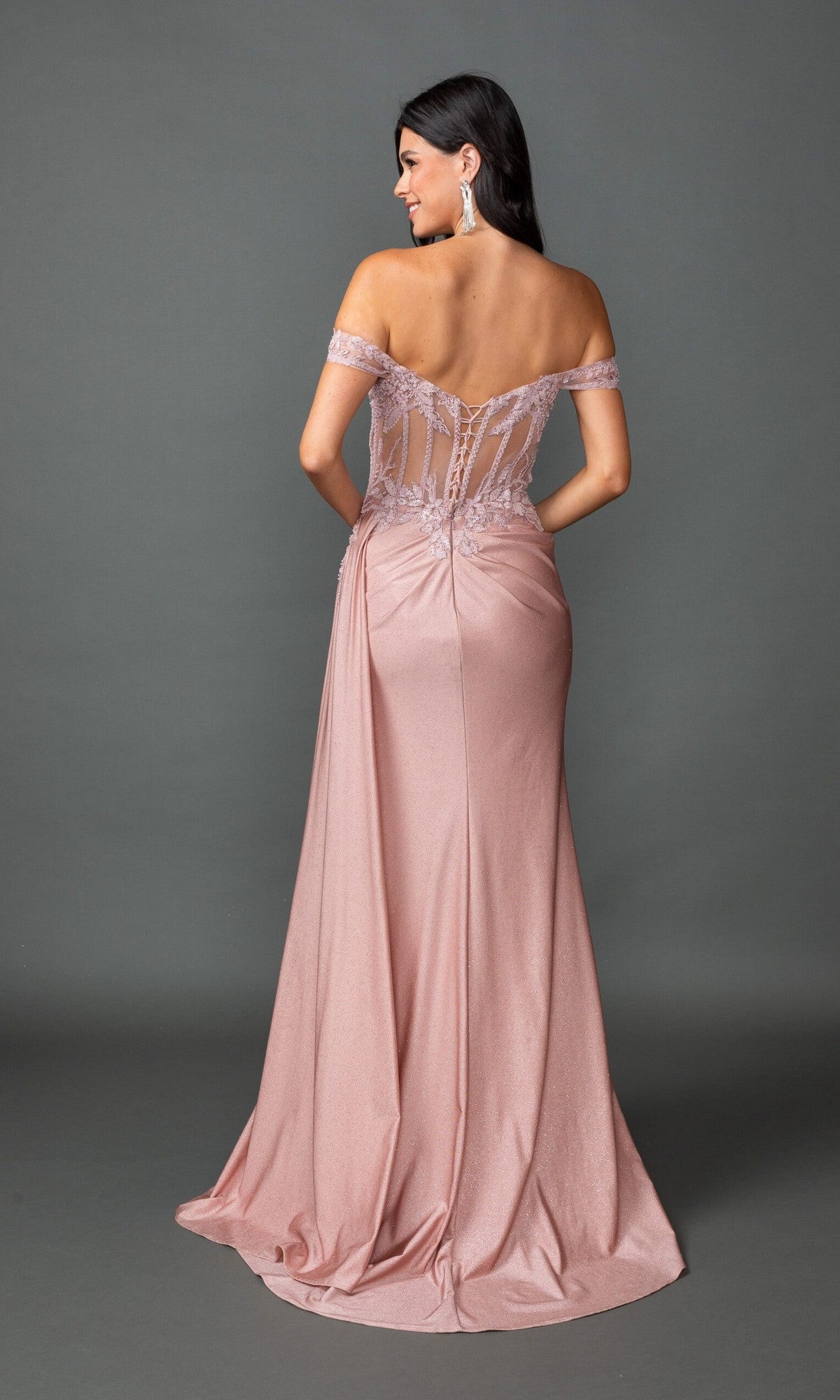 Woman modeling the Long Prom Dress: Dancing Queen 4535 in blush pink, with an off-the-shoulder design, floor-length skirt, and sheer lace embroidered back, posed against a gray background.